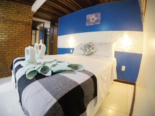 a bedroom with a bed with towels on it at Pousada Guapuruvu in Abraão