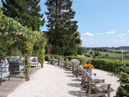 a row of tables and chairs in a garden at Landhaus Eifelsicht in Hellenthal