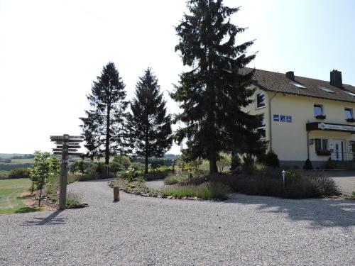 a house with trees and a gravel driveway at Landhaus Eifelsicht in Hellenthal