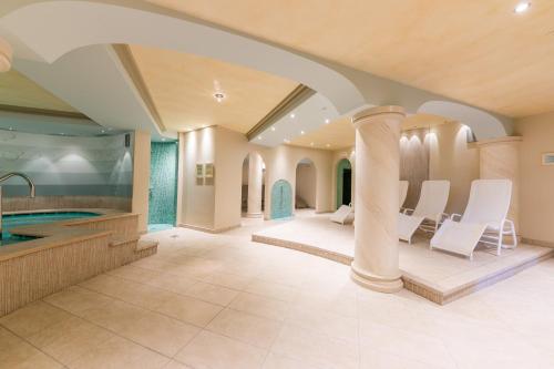 a large bathroom with a tub and a swimming pool at Hotel La Gardenia & Villa Oleandra in Limone sul Garda