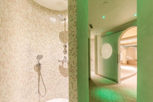 a bathroom with a shower with a green wall at Hotel La Gardenia & Villa Oleandra in Limone sul Garda