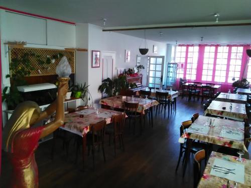 une salle à manger avec tables, chaises et fenêtres dans l'établissement Le Relais De La Marche, à Aigurande