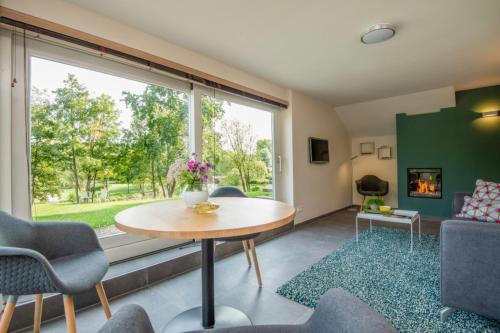 a living room with a table and chairs and a large window at De Gouden Forel in Gulpen