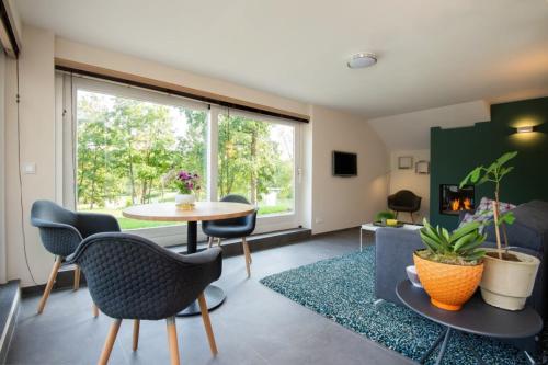 a living room with a table and chairs and a window at De Gouden Forel in Gulpen