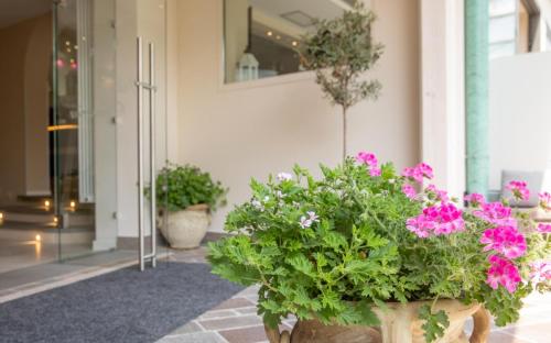 a group of flowers in pots in a hallway at Hotel La Gardenia & Villa Oleandra in Limone sul Garda