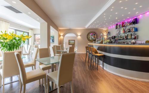 a restaurant with tables and chairs and a bar at Hotel La Gardenia & Villa Oleandra in Limone sul Garda