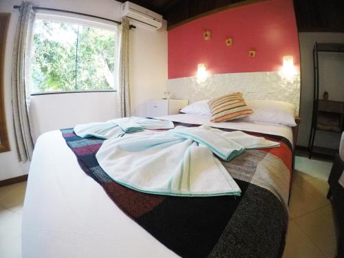 a bedroom with two beds with towels on them at Pousada Guapuruvu in Abraão