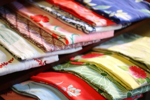 a pile of colorful shirts on a shelf at Aburaya Tousen in Yamanouchi