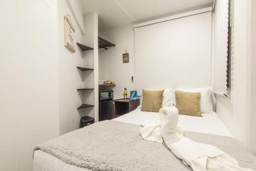 a bedroom with a white bed with a towel on it at Hotel Las Lunas in San Andrés