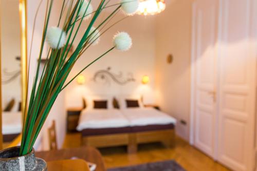 a bedroom with a bed and a table with a vase with flowers at East Private Rooms in Budapest