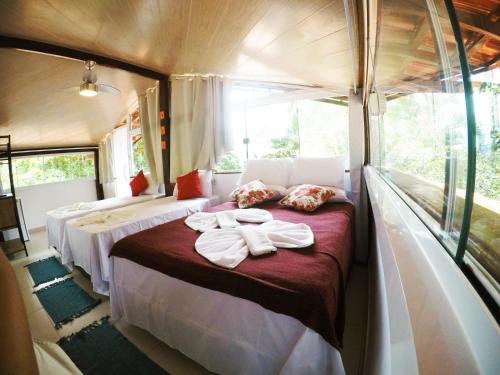 a train room with two beds with towels on it at Pousada Guapuruvu in Abraão
