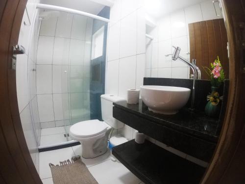 a bathroom with a sink and a toilet and a shower at Pousada Guapuruvu in Abraão