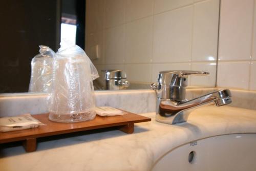 a bathroom sink with a plastic bag on a counter at Hotel Colbert in Saint-Jean-de-Luz