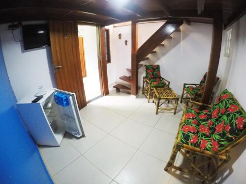 a view of a living room with chairs and a tv at Pousada Guapuruvu in Abraão