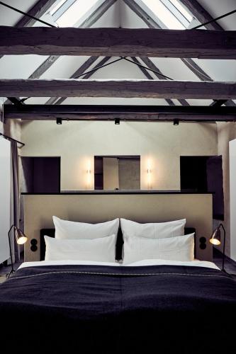 a bedroom with a large bed with white pillows at Fisher's Loft Hotel in Lübeck
