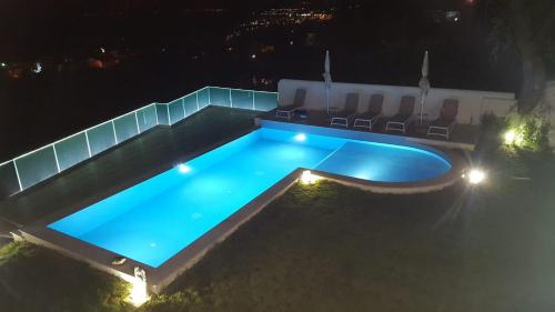 a swimming pool at night with chairs around it at Appartamenti Borgo Panoramico N 5 in Tropea