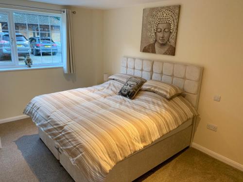 1 dormitorio con 1 cama con una foto en la pared en Fornham Guest House en Chertsey