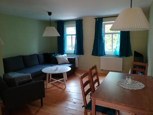 a living room with a couch and a table at Ferienhof"WaldEsel Rippersroda" in Rippersroda
