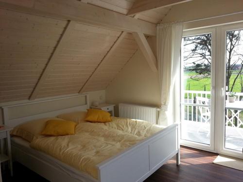 a bed with yellow pillows in a room with a window at Scheunenhaus Kienspan in Tornitz