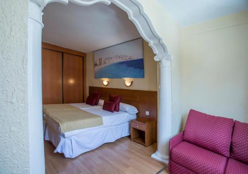 a hotel room with a bed and a chair at Magic Villa de Benidorm in Benidorm