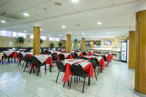 a dining room with red tables and chairs in a restaurant at Magic Villa de Benidorm in Benidorm