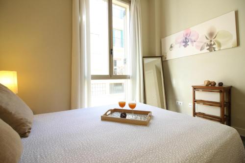 a bedroom with a bed with two glasses on it at Casas FreshApartments in Málaga