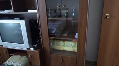 a cabinet with a tv and a tvicterotentotent at 2х комн комфорт Утренний in Koltsovo