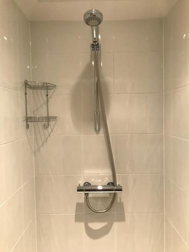 una ducha con cabezal de ducha en un baño en The Bungalow, en Billericay