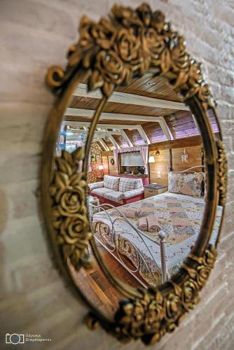 a mirror reflecting a bedroom with a bed and a couch at Traditional Guesthouse in Tríkala