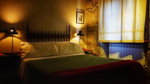 a bedroom with a bed and a window at Posada Puerta Grande in Candelario