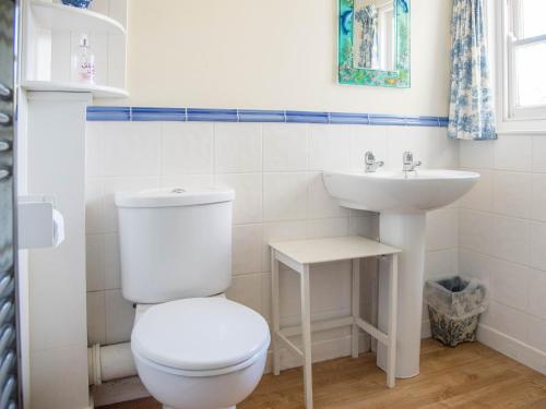 Baño blanco con aseo y lavamanos en Fairhaven, en Thorpeness