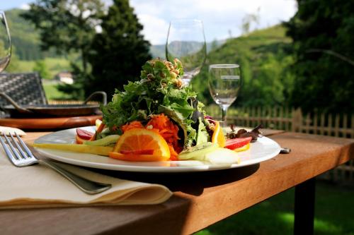 a plate of food on a table with wine glasses at hotel rainhof scheune & naturpark restaurant (Kirchzarten) in Kirchzarten
