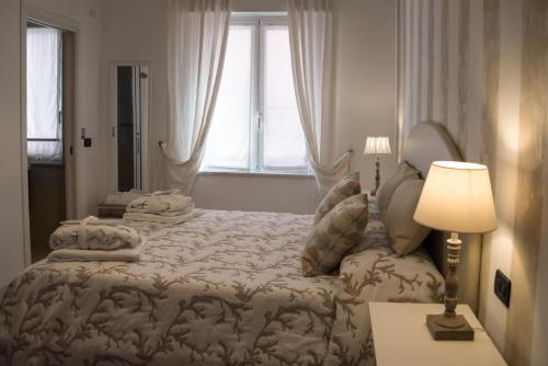 a bedroom with a bed and a lamp and a window at B&B Iulia Augusta in Albenga