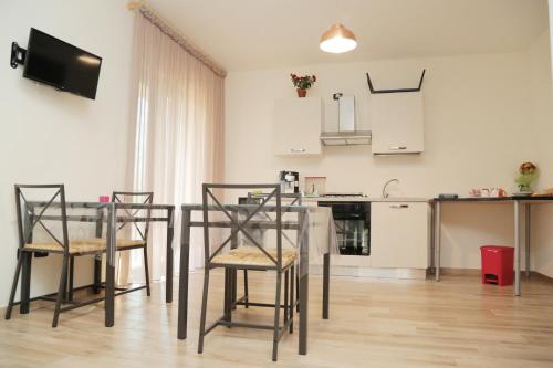 a kitchen with a table and chairs in a room at B & B Evergreen in Corbara
