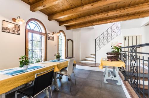 a dining room with a table and chairs and wooden ceilings at LA LOGGETTA - locazione turistica in Bassano del Grappa