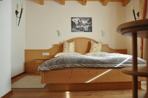 a bedroom with a bed with a wooden head board at Penthouse Kitzpanorama in Kaprun