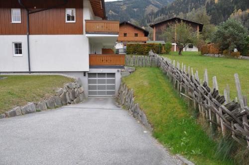 a garage with a fence next to a house at Penthouse Kitzpanorama in Kaprun