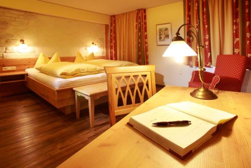 ein Schlafzimmer mit einem Bett und einem Tisch mit einem Notebook in der Unterkunft Gasthaus Sonne in Altusried