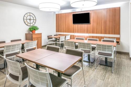 a conference room with tables and chairs and a flat screen tv at Microtel By Wyndham Victor in Victor