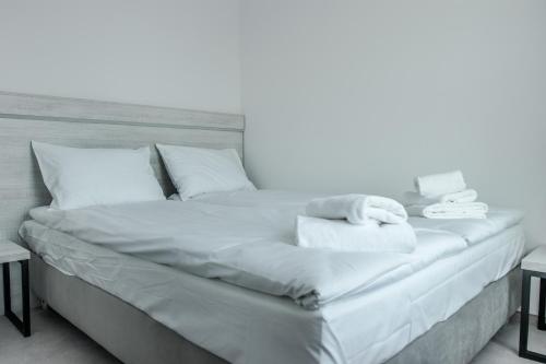 ミエルノにあるMielno Holiday Apartament 401 typu studioの白いベッド(タオル、枕付)