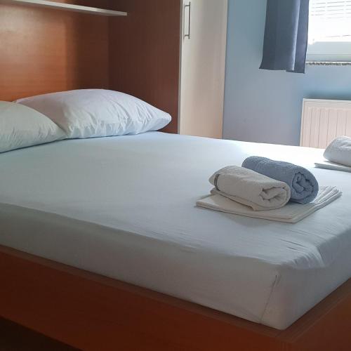 a bed with two towels on top of it at Pool Apartment Knezevic in Novalja