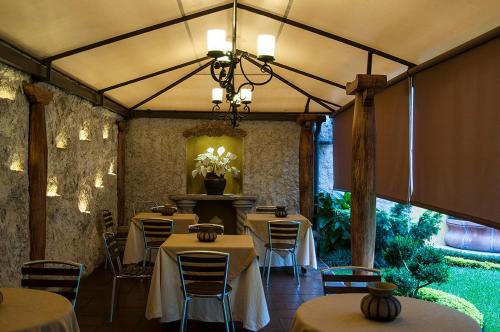 a restaurant with tables and chairs and a chandelier at Hostal Villa Toscana in Guatemala