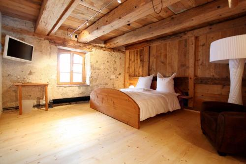 a bedroom with a bed in a room with wooden walls at hotel rainhof scheune & naturpark restaurant (Kirchzarten) in Kirchzarten