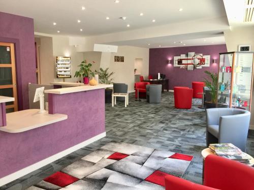 a restaurant with purple walls and red chairs at Hotel Chiffre in Albi