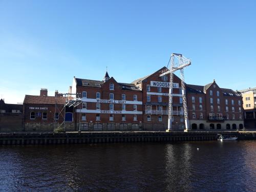 a building with a sign on the side of a river at Riverside Apartment York in York