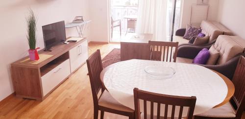 a living room with a table and a tv and a couch at Olimp Lux II in Budva