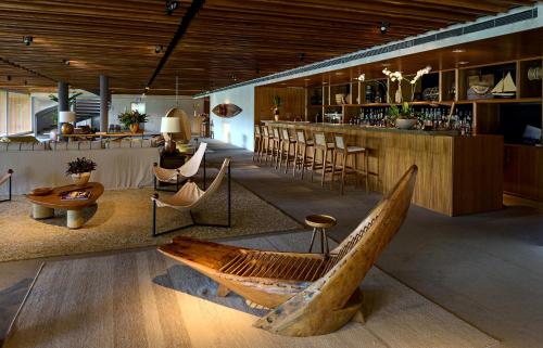 a room with a bar with a wooden boat on the floor at Hotel Fasano Angra dos Reis in Angra dos Reis