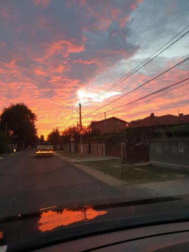 a car driving down a street with a sunset at VillaGrey Tunari in Tunari
