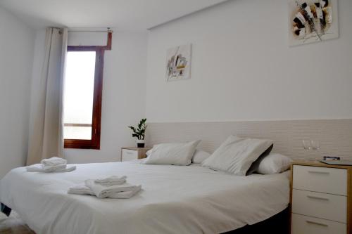 ein Schlafzimmer mit einem weißen Bett und Handtüchern darauf in der Unterkunft Apartamento en Viña del Mar in Playa Fañabe
