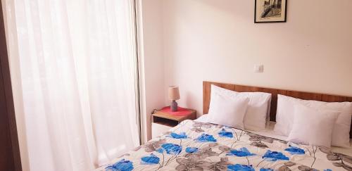 a bedroom with a bed with blue flowers on it at Olimp Lux II in Budva